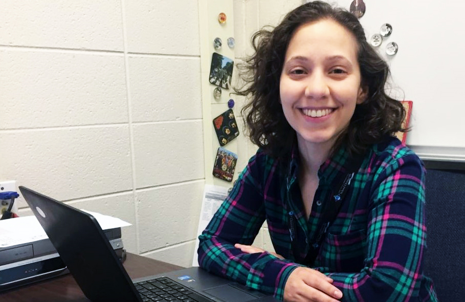 Kim Ferraro smiling sitting down at a computer