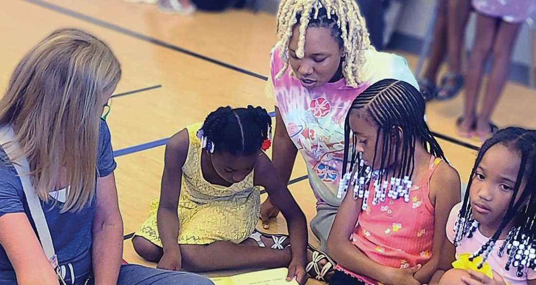 Girls reading on a gym floor
