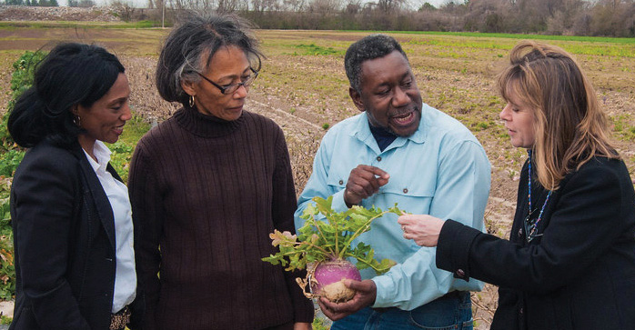 Dean Mildred Griggs in a farm talking to black farmers